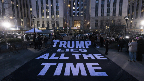 Ciudadanos despliegan un cartel en el que se lee en inglés "Trump miente todo el tiempo" frente la Corte Penal de Nueva York tras la imputación de Tump.