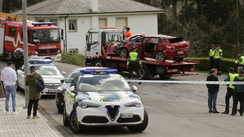 Un Guardia Civil vigila la retirada del coche siniestrado, en el accidente, por una grúa, a 1 de abril de 2023, en Xove (Lugo).