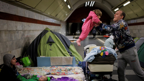 18/03/2022 Alexander Ivoshenko coge en brazos a su hija Kira, mientras su esposa sujeta a su hijo en la estación de metro donde se refugian de los ataques rusos en Kiev, Ucrania