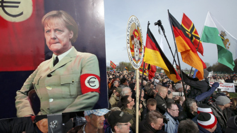 Simpatizantes y seguidores de Peguida, con un cartel de la canciller Angela Merkel, en la manifestación en Dresde.. REUTERS/Fabrizio Bensch