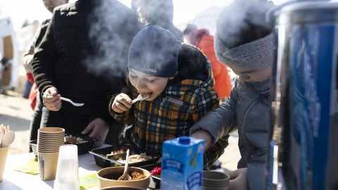 Varios niños se alimentan este lunes en el campamento de refugiados en Budomierz (Polonia), en el paso fronterizo con Ucrania más cercano al bombardeo del IPSC de Yavoriv, a 25 kilómetros de la frontera polaca.