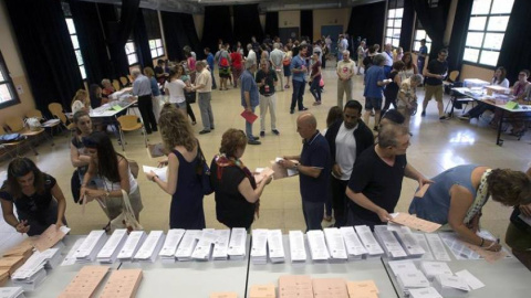 Varios ciudadanos eligen las papeletas en un colegio electoral de Barcelona.- EFE