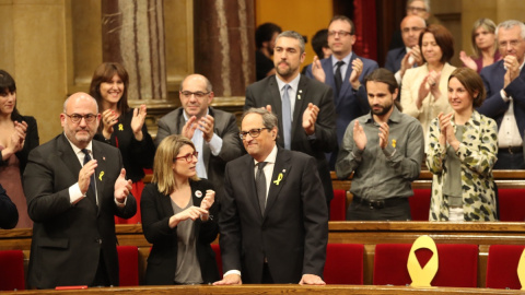 Quim Torra, al costat d'Elsa Artadi i Eduard Pujol, rep els aplaudiments dels diputats de JxCat, després de ser investit com a nou president de la Generalitat. / Parlament de Catalunya