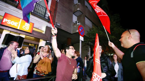 Personas congregadas a las puertas de la sede del PSOE en Madrid desde donde siguen el escrutinio de las elecciones. EFE/ Javier López