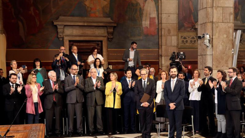 El presidente de la Generalitat, Quim Torra (i), y el del Parlament de Cataluña, Roger Torrent (d), reciben el aplauso de los nuevos consellers del gobierno catalán a su llegada al acto de toma de posesion del nuevo Govern que se celebra ho