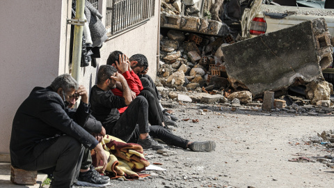 Varias personas lloran la muerte de sus seres queridos tras el devastador terremoto y sus réplicas a lo largo de la frontera turco-siria el pasado febrero.