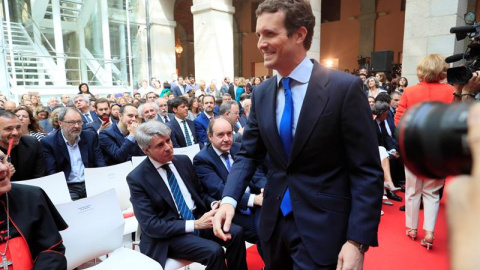 02/05/2019.- El presidente del PP, Pablo Casado (d), pasa por delante del expresidente de la Comunidad de Madrid, Angel Garrido (sentado-2i), a su llegada a los actos conmemorativos de la festividad del Dos de Mayo, Día de la Comunidad de M