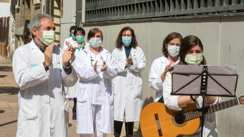 Compañeros del médico José Luis San Martín, primer facultativo fallecido en la provincia de Zaragoza por COVID-19, durante el homenaje que le han rendido a las puertas del Centro de Salud donde desempeñaba su labor. EFE/Javier Cebollada