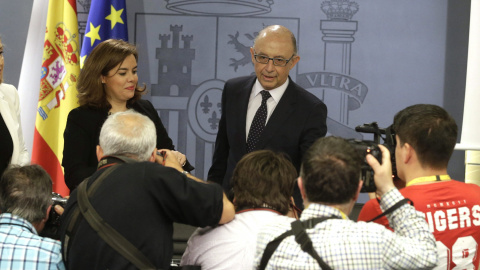 El ministro de Hacienda, Cristóbal Montoro, junto a la vicepresidenta del Gobierno, Soraya Sáenz de Santamaría, antes de la rueda de prensa tras la reunión del Consejo de Ministros. EFE/Angel Díaz