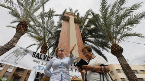 Desde primera hora de la mañana de este martes ciudadanos de La Vall y miembros de la Plataforma Salvemos la Cruz han protestado por las obras de retirada de la cruz que preside la Plaza de España en La Vall d'Uixól. /EFE