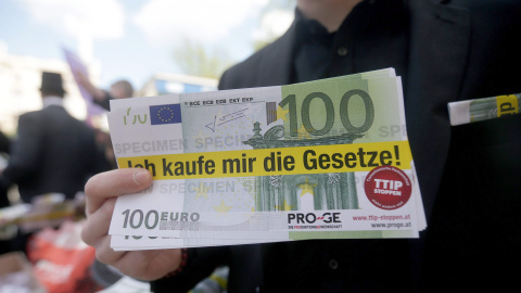 Billetes falsos de 100 euros, con la frase 'Comprame la ley' escrita, en la marcha de Viena contra el TTIP. EFE/EPA/GEORG HOCHMUTH