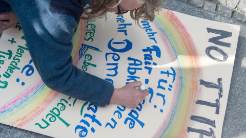 Un manifestante prepara su pancarta contra el TTIP en la manifestacion de Berlín. EFE/EPA/TIM BRAKEMEIER