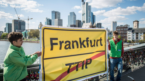 Dos activistas de Greenpeace con un pancarta contra el TTPI, con el 'skyline' de Fráncfort, la capital financiera de la UE. EFE/EPA/FRANK RUMPENHORST