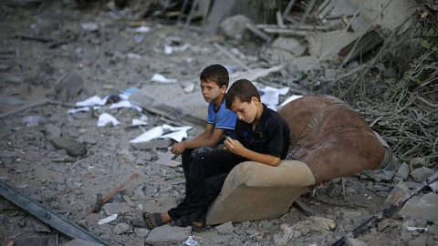 Niños palestinos tras un bombardeo de Israel. REUTERS