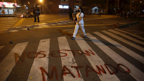 Una mujer pasa junto a una pintada donde se lee "Nos están matando" durante una protesta por la muerte del abogado Javier Ordóñez, en Bogotá. EFE/ Ernesto Guzmán Jr