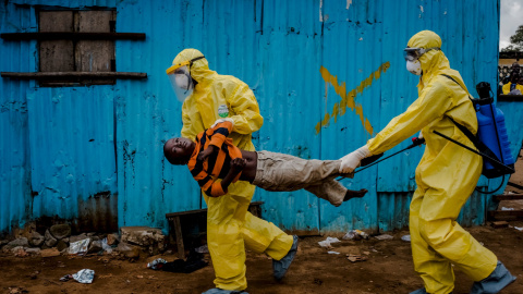 Trabajadores médicos llevan a James Dorbor, 8 años, porque sospechan que pueda tener ébola, a un centro de tratamiento en Monrovia, Liberia./  REUTERS/Daniel Berehulak/The New York Times