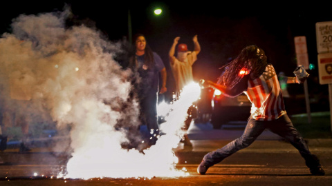 Edward Crawford devuelve un bote de gas lacrimógeno disparado por la policía, que intentaba dispersar la protesta en Ferguson, Mossouri, Estados Unidos./ REUTERS/Robert Cohen/St. Louis Post-Dispatch/Handout