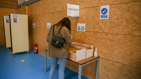 Una mujer elige su papeleta en las elecciones del 4 de mayo de 2021 en Madrid