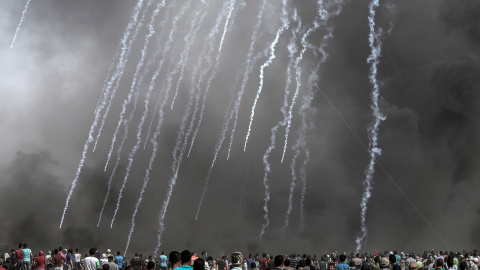 Cientos de palestinos observan las cápsulas de gases lacrimógenos lanzadas por Israel hacia los territorios palestinos en Gaza. EFE/Mohammed Saber