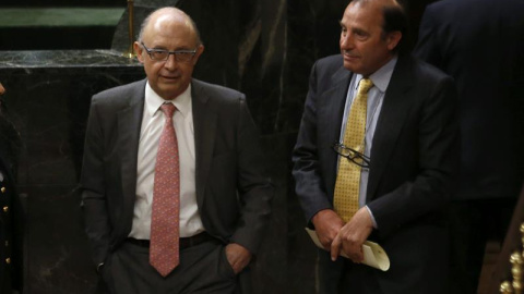 El portavoz de Economía del PP, Vicente Martínez Pujalte, conversa con el ministro de Hacienda Cristóbal Montoro, durante el pleno celebrado hoy en el Congreso de los Diputados. EFE/Juan Carlos Hidalgo