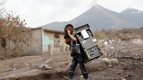 Un hombre recupera algunos objetos de su casa afectada por la erupción del Volcán de Fuego./REUTERS