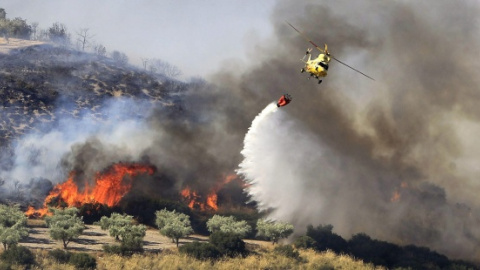 Un helicóptero participa en labores de extinción de un incendio en la Comunidad de Madrid.