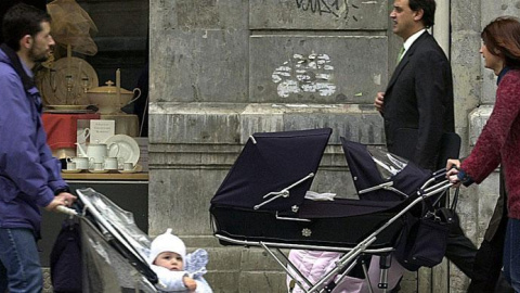 Un padre y una madre pasean sus cochecitos de bebé. EFE/Archivo