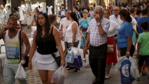 Personas con bolsas de la compra en la calle de La Bola, Ronda, España. REUTERS/Jon Nazca