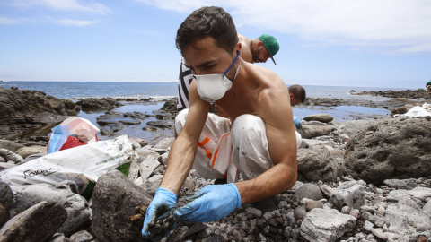 Un voluntario realiza labores de limpieza en una de las playas afectadas de Gran Canaria. EFE