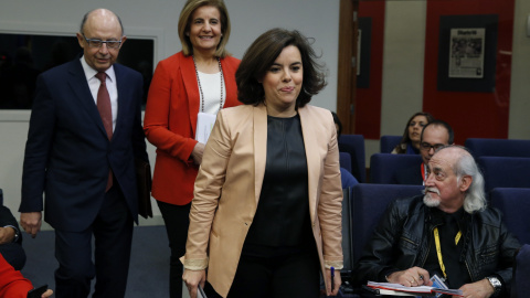 La vicepresidenta del Gobierno, Soraya Saenz de Santamaría, acompañada por los ministros de Hacienda y de Empleo, Cristóbal Montoro y Fátima Báñez, respectivamente, a su llegada a la rueda de prensa posterior a la reunión del Consejo de Min