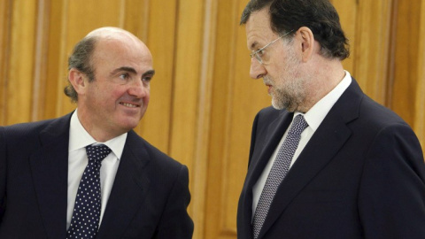 El ministro de Economía, Luis de Guindos, y el presidente del Gobierno, Mariano Rajoy, en una foto de junio de 2011 en el Palacio de la Zarzuela, en la jura del cargo del gobernador del Banco de España Luis Maria Linde.AFP