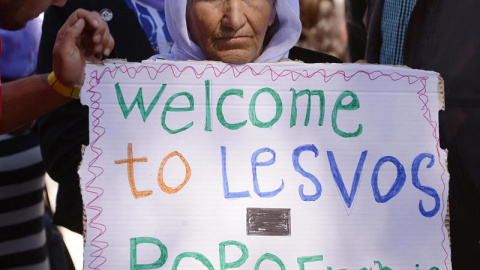 Una mujer sujeta una pancarta de bienvenida al Papa en el centro de detención de Moria. - EFE