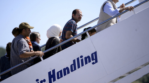 Los refugiados sirios retenidos en Lesbos suben al avión con dirección a Roma. REUTERS/Filippo Monteforte/Pool