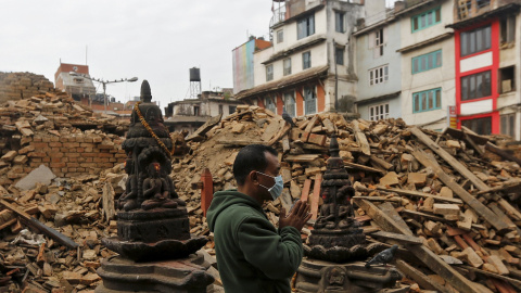 Un hombre reza al lado de los escombros de un templo, destruido el sábado a causa del terremoto, en Katmandú, Nepal./ REUTERS/Adnan Abidi