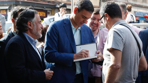 El presidente del Gobierno en funciones y secretario general del PSOE, Pedro Sánchez, saluda a unos simpatizantes durante su visita este miércoles al barrio madrileño de Usera. - EFE