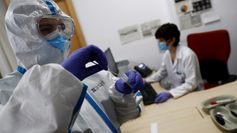 Imagen de archivo de un trabajador sanitario con una muestra de un test de coronavirus.