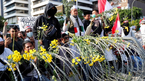 22/09/2019 - Activistas indonesios colocan flores sobre la alambrada de espino durante una protesta | EFE/ Adi Weda