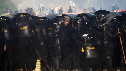 22/05/2019 - Miembros de la policía se cubren durante una protesta en los alrededores de la sede del Consejo de Supervisión Electoral  | EFE/ Bagus Indahono