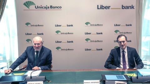 El presidente de Unicaja, Manuel Azuaga (i) junto con el consejero delegado de Liberbank, Manuel Menéndez (d) durante la firma de la fusión entre ambas entidades en un acto celebrado  en Málaga. EFE