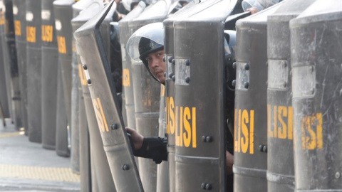 Policías indonesios se protegen tras sus escudos durante una manifestación | EFE/ Adi Weda