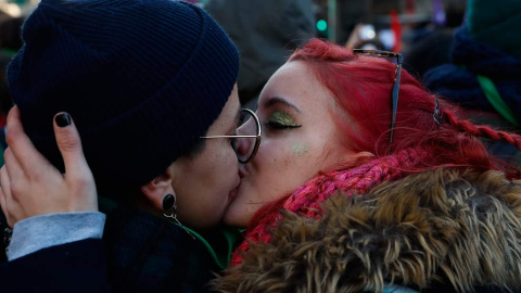 Dos mujeres se besan tras la aprobación de la ley del aborto. (DAVID FERNÁNDEZ | EFE)