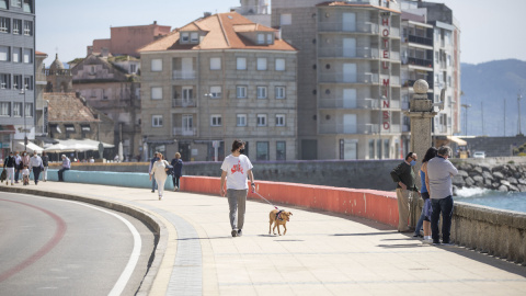 Varias personas pasean por el Paseo Marítimo de Sanxenxo, en Pontevedra, Galicia, a 27 de marzo de 2021.