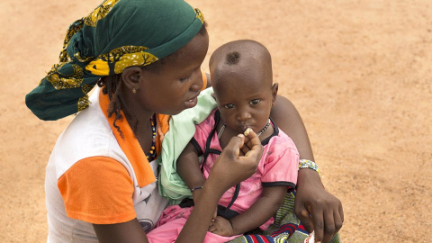 Una madre da de comer a su hijo desnutrido en Burkina Faso.