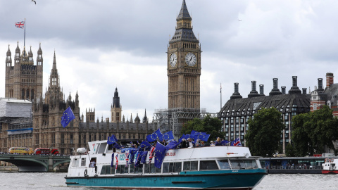 Un grupo de opopsitores al Brexit, con banderas de la UE en una barcaza por el Támesis de Londres, frente al edificio del Parlamento y la torre del 'Big Ben'. REUTERS/Luke MacGregor