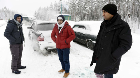 Un refugiado afgano (i) y un paquistaní (d) esperan cerca de la localidad rusa de Kuoloyarvi a poder cruzar la frontera con Finlandia, que junto a Noruega, bloqueó la ruta del Ártico en 2016 - AFP