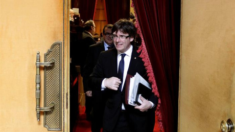 El presidente de la Generalitat, Carles Puigdemont, abandona el hemiciclo del Parlament de Catalunya, tras la sesión de control al gobierno que se ha producido pocas horas antes de que el presidente catalán se reúna en la Moncloa con el pre