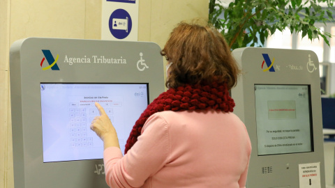 Una contribuyente recoge su turno en una oficina de la Agencia Tributaria para hacer la declaración de la renta, en abril de 2021.