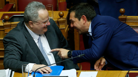 El primer ministro griego, Alexis Tsipras, conversa con el ministro de Exteriores,Nikos Kotzias, durante la moción de censura en el Parlamento griego.-  REUTERS