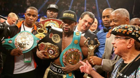 Mayweather con los cinturones de campeón./ REUTERS