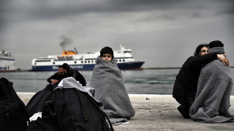 Un niño refugiado cubierto con mantas en el puerto de Mitilene, en Lesbos. ARIS MESSINIS / AFP